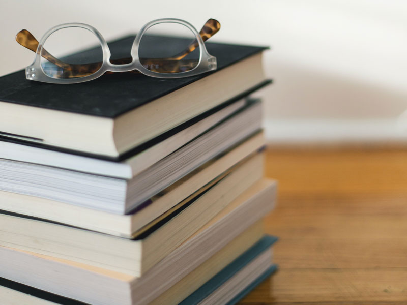 Stack of books with a set of glasses on top