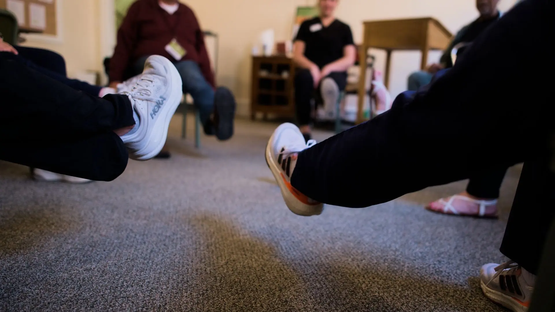 people with dementia engaging in leg lifting exercises during a dementia support session at the Magnolia Center for Brain Health